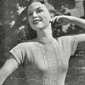 May include: A vintage knitting pattern for a women's short-sleeved sweater with a diamond-shaped lace pattern down the front. The pattern is from Patons & Baldwins.