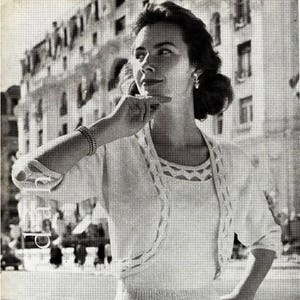 Puede incluir: Un patrón de tejido de punto vintage para un suéter blanco con un diseño de encaje. El patrón incluye instrucciones para un cárdigan y una blusa a juego.