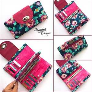 May include: A pink and teal floral wallet with a flap closure and a silver clasp. The wallet is open to reveal multiple card slots and a cash compartment. The wallet is made of fabric and has a floral print.