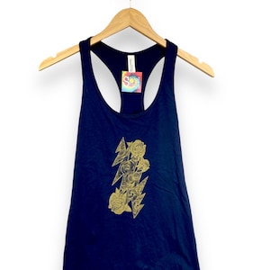 May include: A navy blue tank top with a gold lightning bolt and rose design. The tank top has a scoop neck and racerback style.