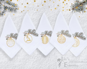 Könnte beinhalten: Fünf weiße Servietten mit goldenen gestickten Weihnachtskugeln, die an einem Tannenzweig hängen. Die Kugeln haben verschiedene Designs, darunter ein Rentier, eine gestreifte Kugel und ein Wirbelmuster.