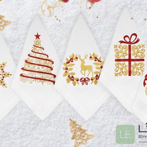 May include: Five white napkins with gold and red embroidered Christmas designs. The designs include a snowflake, a Christmas tree, a wreath with a deer, a gift box, and two ornaments.