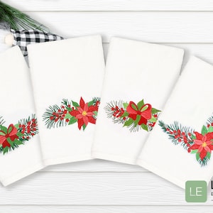 Könnte beinhalten: Vier weiße Handtücher mit gestickten Weihnachtsmotiven. Jedes Handtuch zeigt ein Eckdesign aus grünen Kiefernästen, roten Beeren, einer roten Weihnachtsstern-Blume und einer roten Schleife.