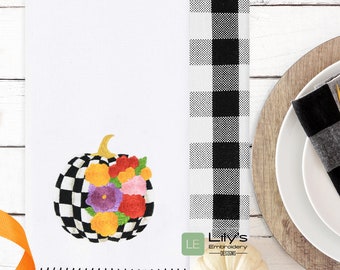 Könnte beinhalten: Ein weißes Küchentuch mit einem schwarz-weiß karierten Kürbis, auf dem bunte Blumen gestickt sind. Das Tuch hat einen schwarzen gestickten Rand. Der Text "Lily's Embroidery Designs" befindet sich in der rechten unteren Ecke des Tuches.
