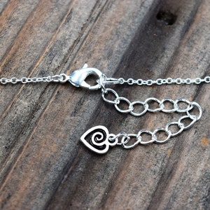 Puede incluir: Collar de cadena de plata con cierre de langosta y un dije en forma de coraz&oacute;n con un dise&ntilde;o de espiral.
