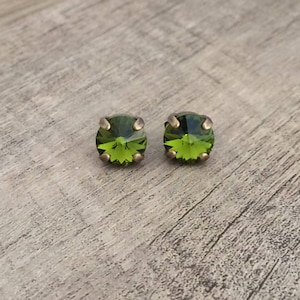 May include: A pair of green crystal stud earrings with antique gold settings.