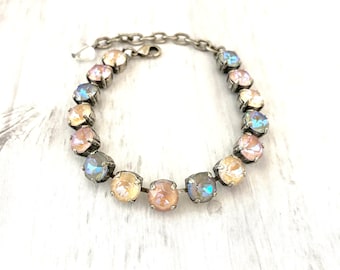 May include: A silver chain bracelet with iridescent pastel pink, blue, and beige crystals.