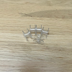 May include: A set of six clear plastic bobbins for a sewing machine.