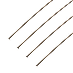 May include: Four bronze-coloured head pins are shown, each with a flat, circular head and a long, slender wire shaft. The pins are arranged diagonally against a white background, suggesting their use in jewellery making or crafting.