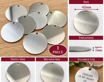 May include: A 42mm round stainless steel stamping blank with a 3mm hole and 1mm thickness. The metal disc features a dual-sided finish with one side being smooth and shiny, and the reverse side having a brushed texture. Includes an example keychain.
