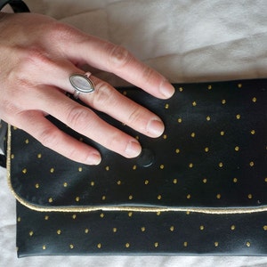 Black leather faux clutch and golden polka dots with gold piping