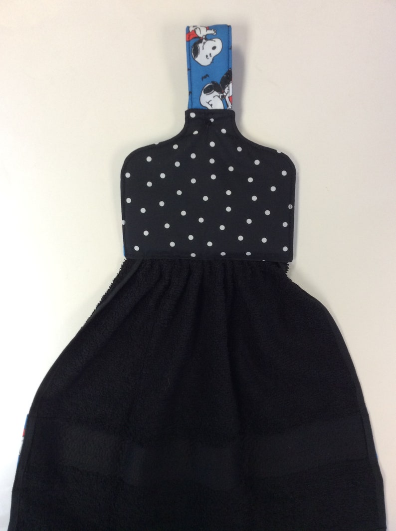 Peut inclure: Porte-serviette de cuisine noir et blanc &agrave; pois avec une poign&eacute;e en tissu bleu et blanc repr&eacute;sentant des personnages de dessins anim&eacute;s. La poign&eacute;e a une boucle pour accrocher.