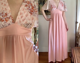 May include: A long, pink maxi dress with a V-neckline and short, sheer sleeves. The dress has a floral print on the bodice and a solid pink skirt.