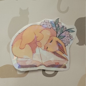 Eevee on Book Holographic Sticker