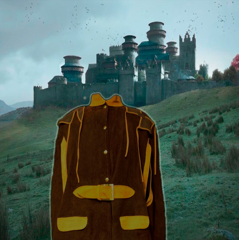 May include: A brown suede jacket with yellow accents and a belt. The jacket has a high collar and a button closure. The jacket is in front of a blurry background of a castle.