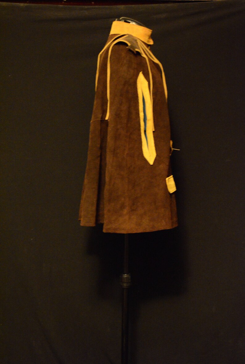May include: A brown suede jacket with yellow trim and a blue lining. The jacket is on a black stand.