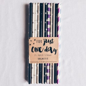 May include: A pack of 25 paper straws with a variety of patterns, including black and white stars, purple stripes, and gray stripes. The pack is labeled "For just one day 25 paper straws Galactic forjustoneday.co.uk @forjustonedayatelier"