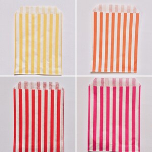 Pu&ograve; includere: Quattro sacchetti di carta a righe di diversi colori. I sacchetti sono giallo e bianco, arancione e bianco, rosso e bianco e rosa e bianco.