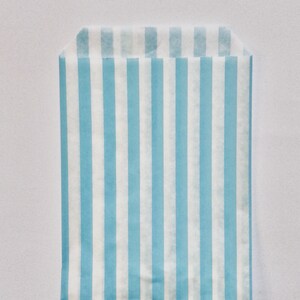 Pu&ograve; includere: Un sacchetto di carta a strisce blu chiaro e bianco. Il sacchetto &egrave; fatto di carta sottile e ha la parte superiore piegata.