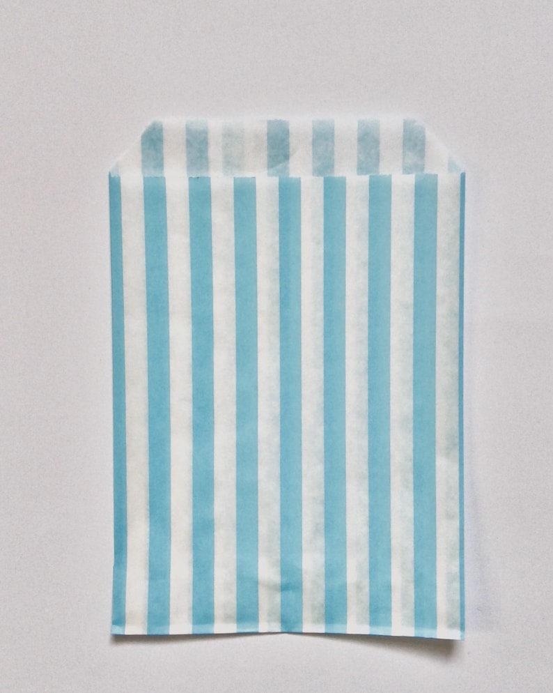 Pu&ograve; includere: Un sacchetto di carta a strisce blu chiaro e bianco. Il sacchetto &egrave; fatto di carta sottile e ha la parte superiore piegata.