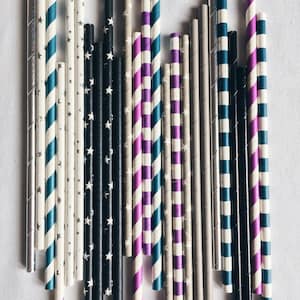 May include: A collection of colorful striped paper straws in various patterns, including black and white, blue and white, purple and white, and gray and white.