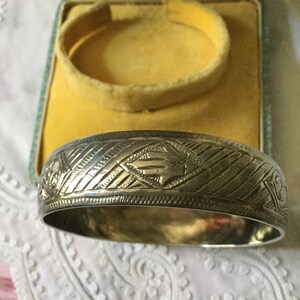 Peut inclure: Un bracelet en argent avec un motif géométrique. Le bracelet est gravé d'un motif répété de diamants et de lignes. Le bracelet est dans une boîte en velours jaune.