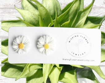 May include: A pair of white daisy earrings with yellow centers, displayed on a white card with the text "Wishing Flower Jewelry" and the website address "WishingFlowerJewelry.etsy.com".