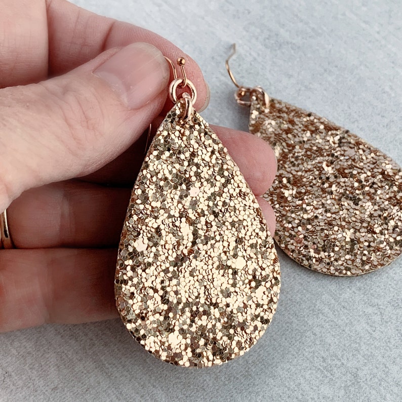 May include: Gold glitter teardrop earrings with a gold hook fastening.