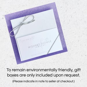 May include: A white gift box with a silver ribbon tied in a bow. The box has a white card on top with the text "Enjoy your gift!" and the logo "Wishing Flower Jewellery". The text "To remain environmentally friendly, gift boxes are only included upon request. (Please indicate in note to seller at checkout.)" is below the image.
