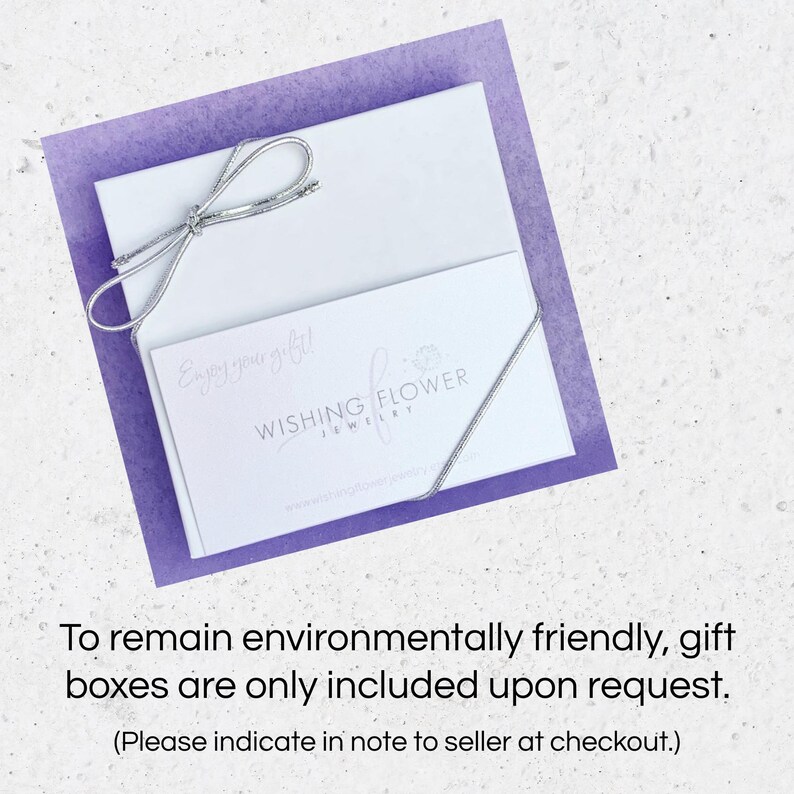 May include: A white gift box with a silver ribbon tied in a bow. The box has a white card on top with the text "Enjoy your gift!" and the logo "Wishing Flower Jewellery". The text "To remain environmentally friendly, gift boxes are only included upon request. (Please indicate in note to seller at checkout.)" is below the image.