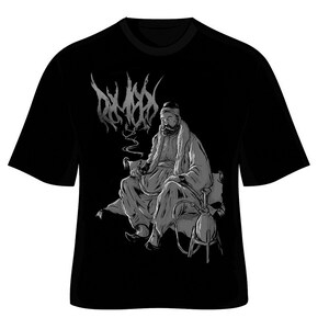 May include: Black t-shirt with a silver graphic of a man sitting on a cushion, smoking a hookah, with the word "DYMXD" in a stylized font above him.