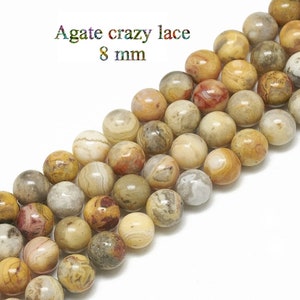 Peut inclure: Un brin de perles d'agate crazy lace de 8 mm. Les perles sont rondes et présentent une variété de couleurs brunes, blanches et orange.