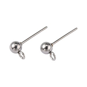Peut inclure: Deux tiges d'oreille en argent avec une petite boule ronde au sommet et une boucle en bas.