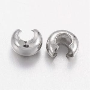 Peut inclure: Deux cache-perles à sertir argentés et brillants. Ces apprêts de bijouterie ont une forme de demi-cercle avec une ouverture fendue, conçus pour dissimuler les perles à sertir. Les perles ont une surface lisse et réfléchissante, idéale pour la création de bijoux.