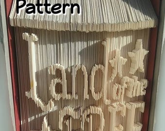 May include: A book with the words "Land of the Free" and "Home of the Brave" folded into the pages. The book is a light brown color and the words are white. The book is titled "Pattern" and "PreMadeReMade" at the top and bottom of the image.