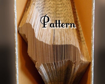 May include: A book folded into the shape of a bird, with the pages fanned out to reveal the intricate folds. The book is open to reveal the inside pages, which are a light brown color. The text "Pattern" is printed in black on the inside pages. The text "Prelude Records 2015" is printed in black on the bottom edge of the book.