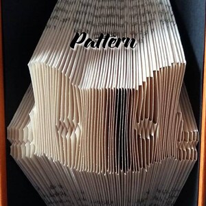 May include: A book folded into a 3D pattern, with the word "Pattern" written on the front. The book is displayed in a black box with an orange border.