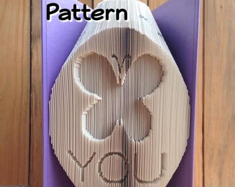 May include: A purple book with the words "Pattern" and "PreMadeReMade" printed on the cover. The book is folded into a 3D butterfly shape with the word "YOU" visible in the center.
