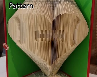 May include: A book folded into the shape of a football, with the words "Pattern" and "PreMadeReMade" visible. The football is on a green background with a white border and a red border.