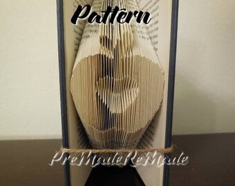 May include: A book with a folded paper design of a heart shape. The book is bound in blue and has the text "Pattern" and "Pre Made Remark" printed on the cover.