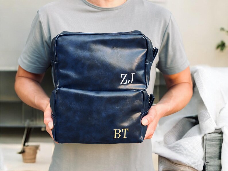 May include: Two blue leather zippered travel bags with gold initials "ZJ" and "BT" on the front.