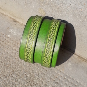 Peut inclure: Bracelet en cuir vert avec un motif de nœud celtique.