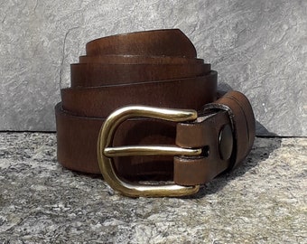 May include: A rolled-up brown leather belt with a brass buckle. The belt is made of a rich, dark brown leather and features a classic, rounded brass buckle. The belt is approximately 1.25 inches wide.
