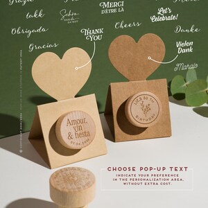 May include: Wooden wine stoppers with personalized text options, displayed with heart-shaped cards. One stopper is engraved with "Amour, vin & fiesta 07.06.2026", and another with "LIZ.S 50 TH BIRTHDAY". The image includes text options like "Thank You" and "Cheers".