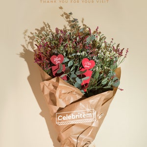 May include: A bouquet of dried flowers wrapped in brown paper, featuring red heart-shaped cards that read "Thank You" and "With love." The bouquet includes purple and white flowers and green eucalyptus leaves. The text "Thank you for your visit" is at the top.