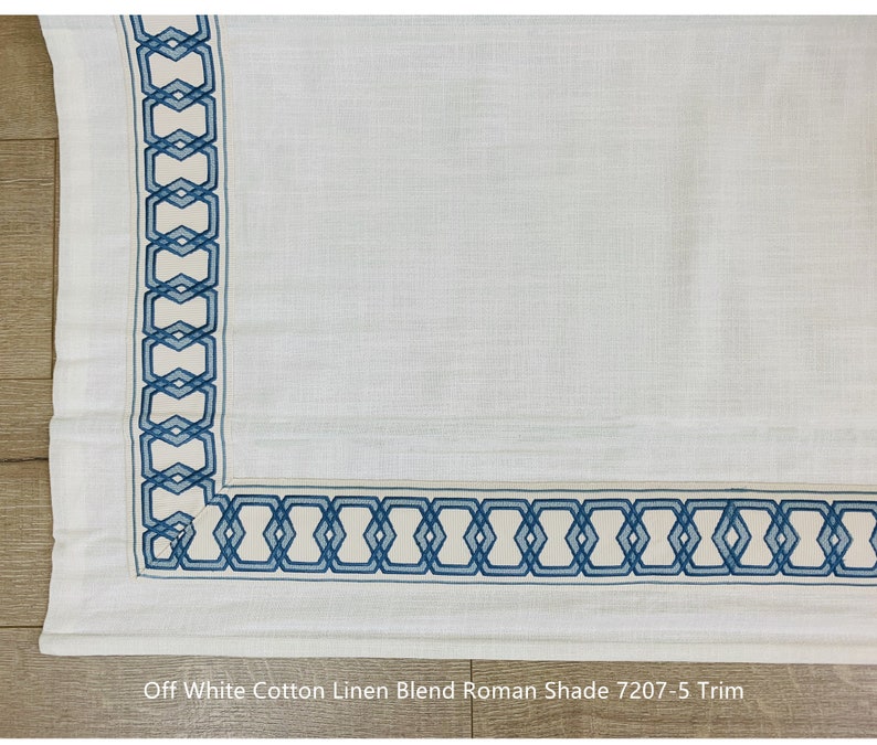 May include: Off white cotton linen blend Roman shade with a blue geometric trim.  "Off White Cotton Linen Blend Roman Shade 7207-5 Trim" is written at the bottom of the image.