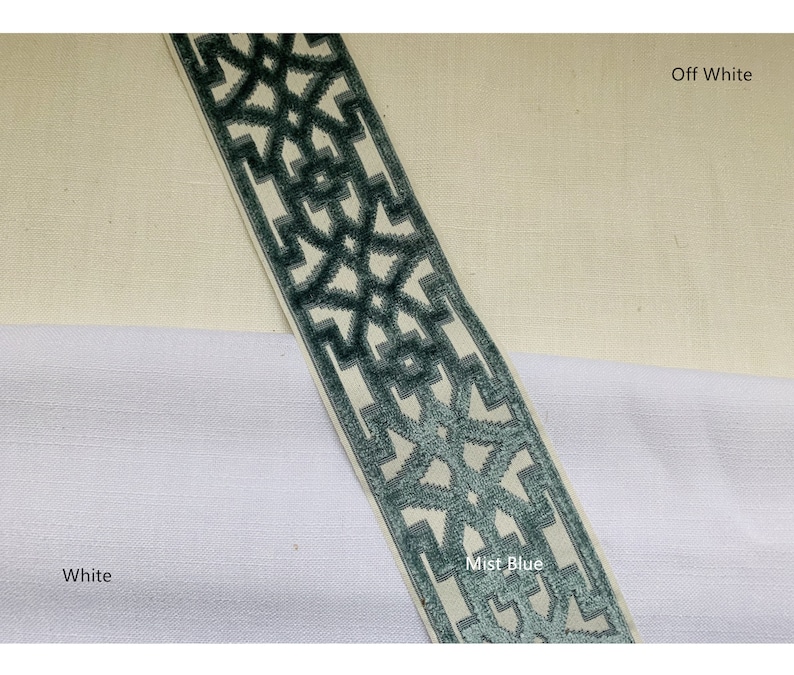 May include: A close-up of fabric swatches in white, off-white, and mist blue. The fabric has a geometric pattern in a darker blue color. The text "Mist Blue" is written on the fabric swatch.