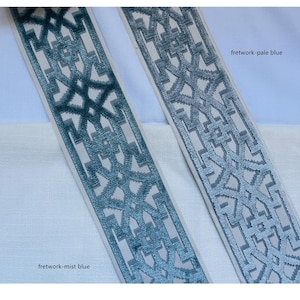 May include: Two samples of blue and white patterned trim fabric. The trim on the left is a darker blue called "fretwork-mist blue". The trim on the right is a lighter blue called "fretwork-pale blue".