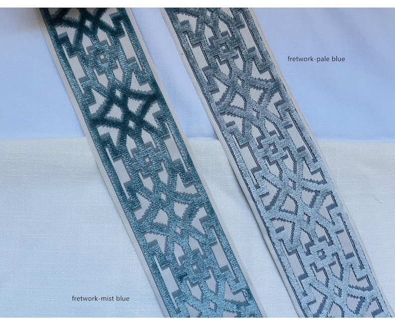 May include: Two samples of blue and white patterned trim fabric. The trim on the left is a darker blue called "fretwork-mist blue". The trim on the right is a lighter blue called "fretwork-pale blue".
