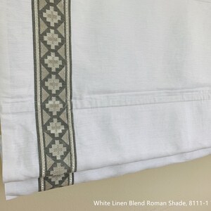May include: White linen blend Roman shade with a gray and white geometric trim. The shade is fully extended and shows the fabric texture.